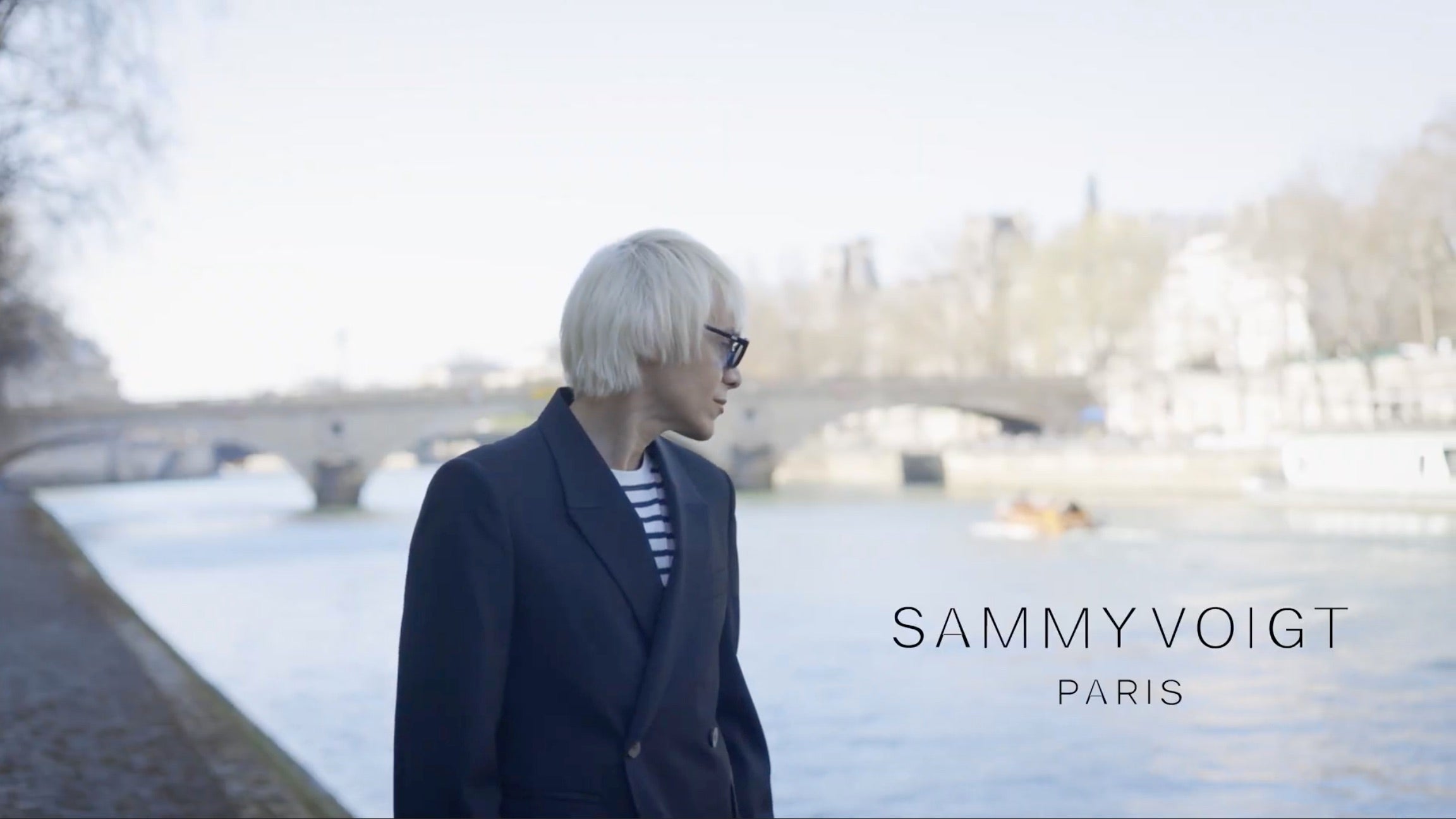 Sammy Voigt in front of Seine river wearing Sammy Voigt Paris stripes tshirt and blazer