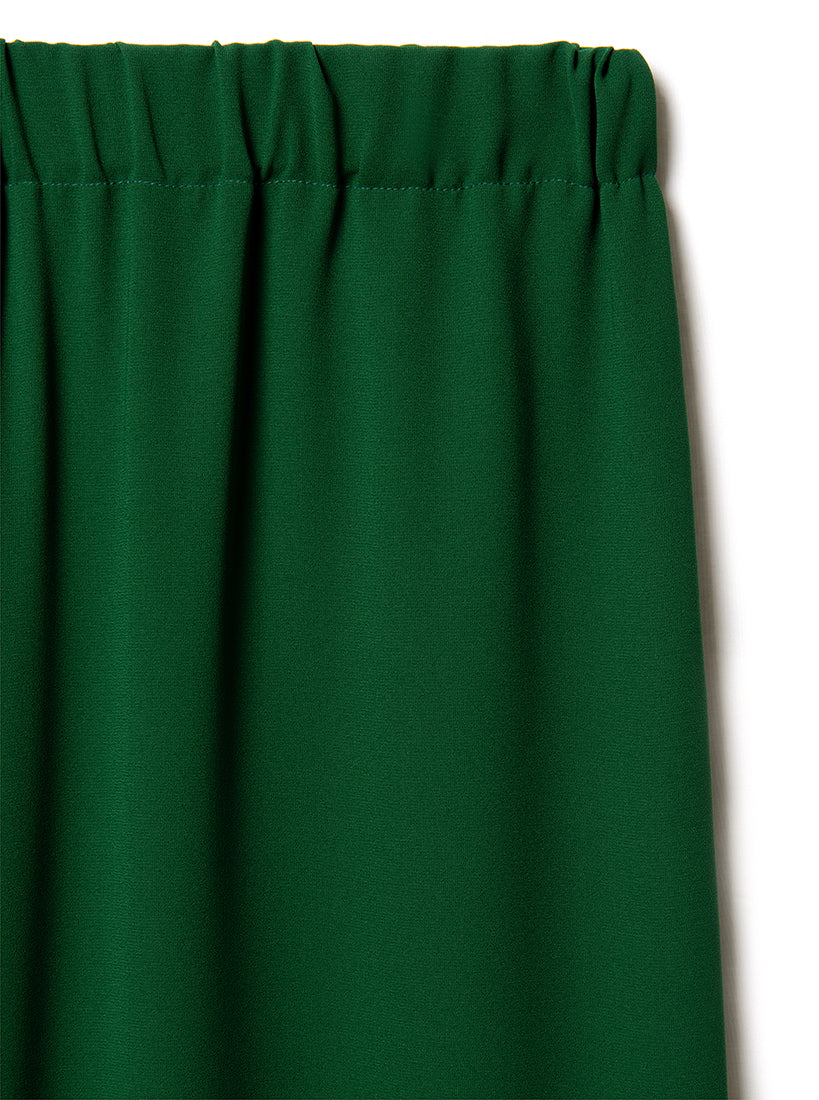 Green silk trousers  elastic waist with a plain background