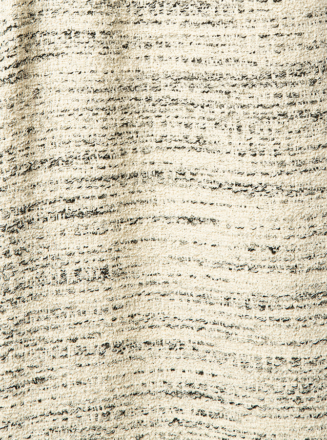 Close-up of textured beige fabric with a subtle pattern in black