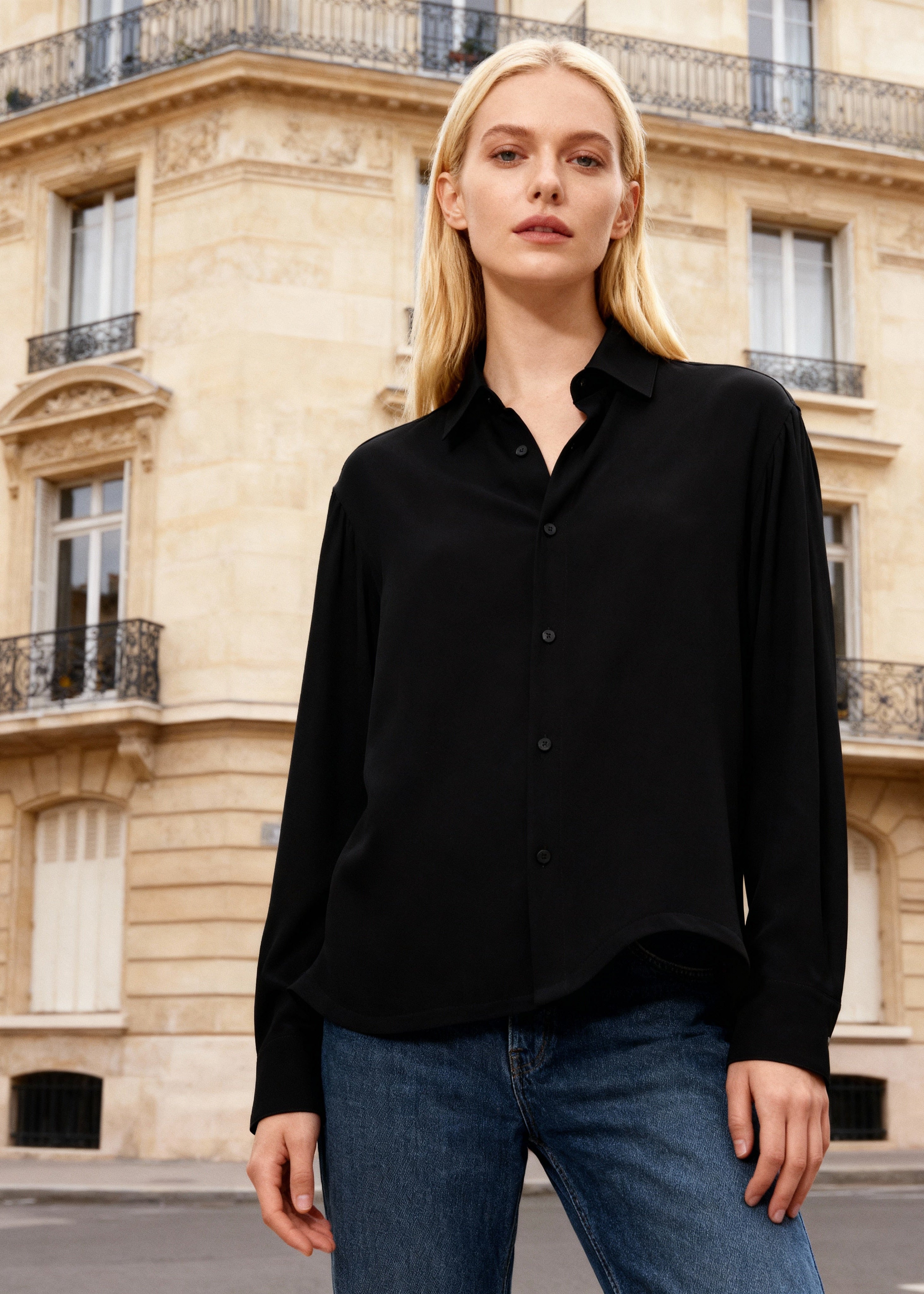 female blonde model wears black silk shirt with jeans