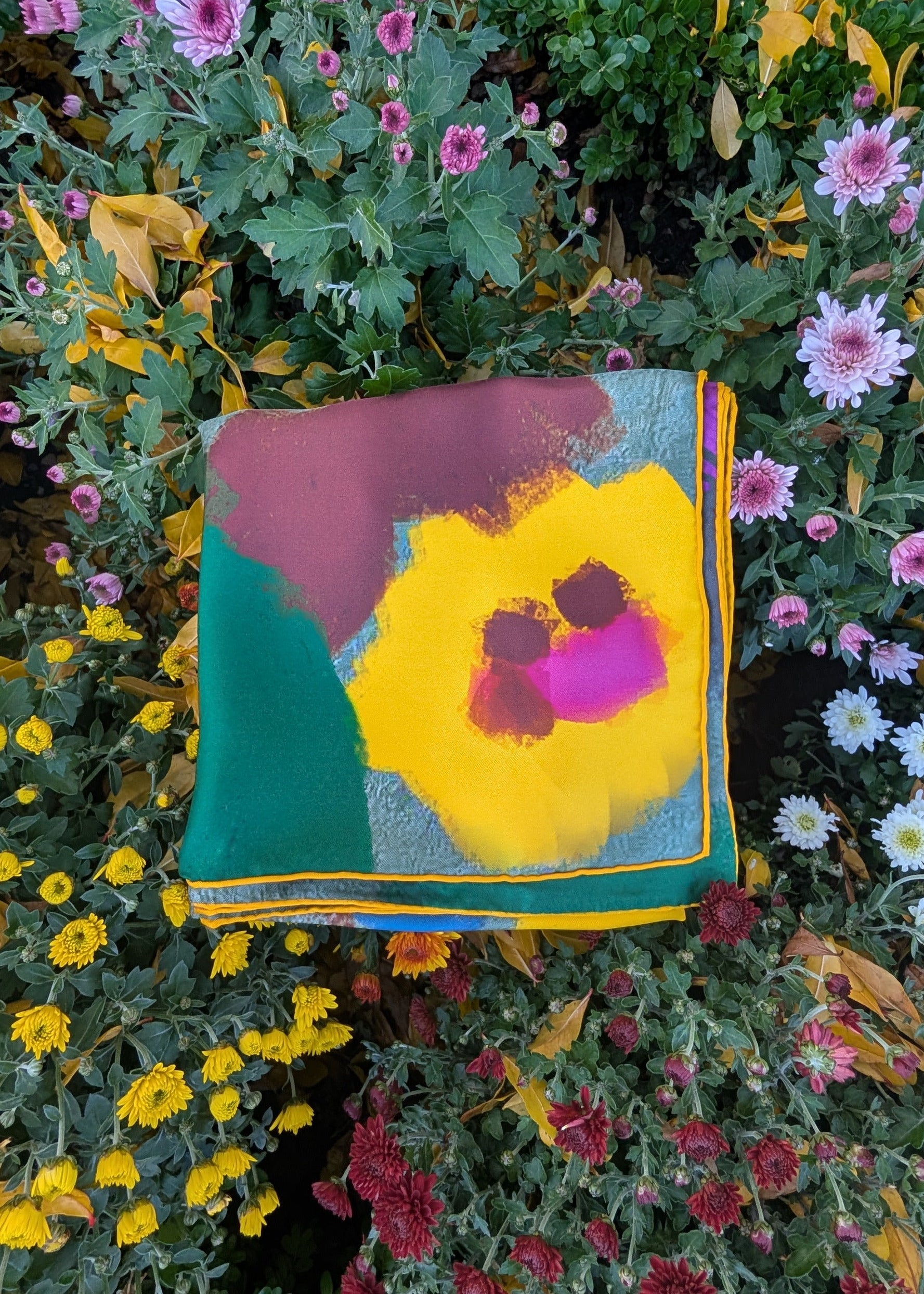 Colorful floral-patterned silk square among flowers