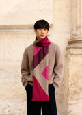 asian male model wears a pink red and beige geometric motiv wool scarf in front of Parisian wall
