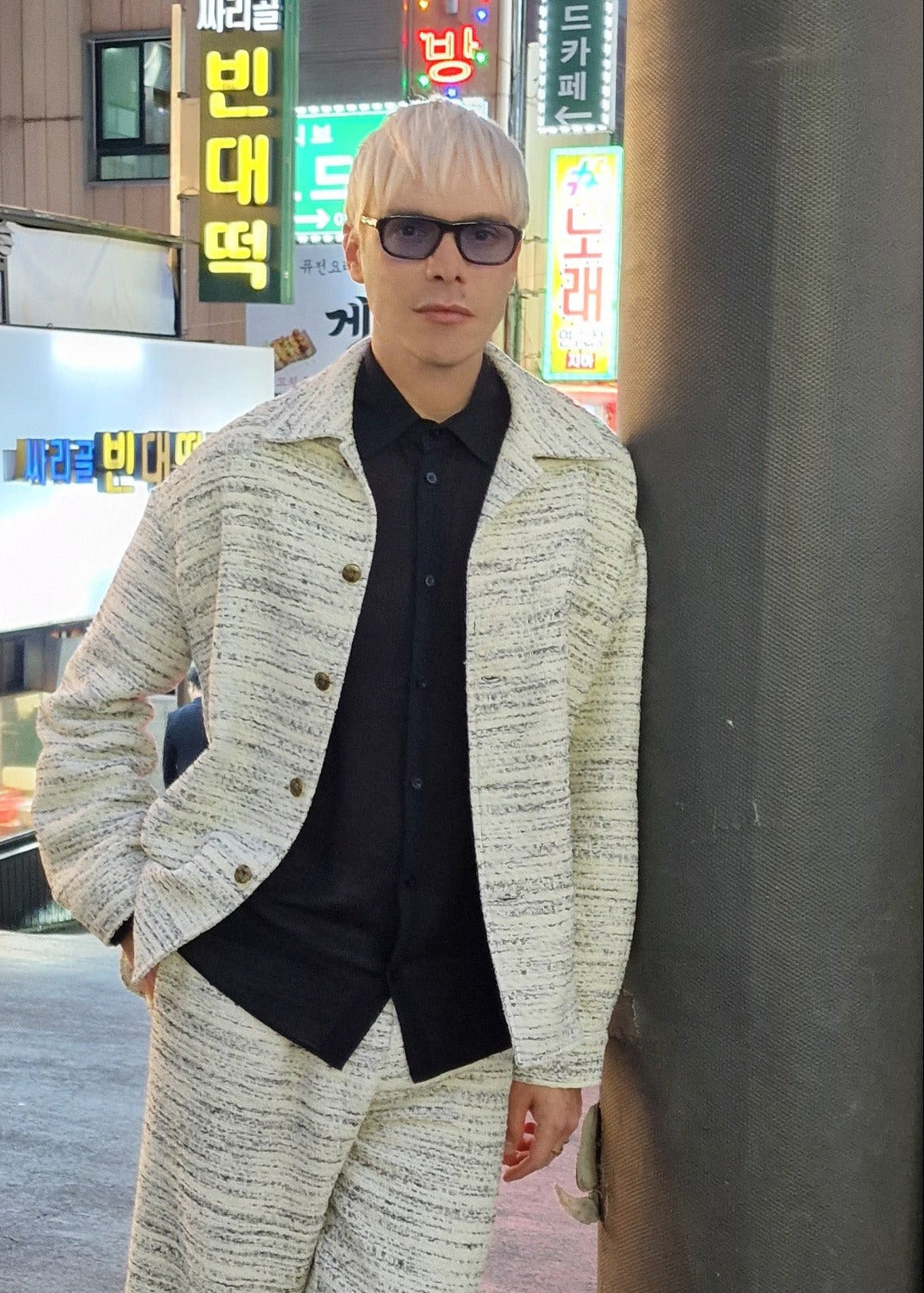 model wears a tweed jacket in beige