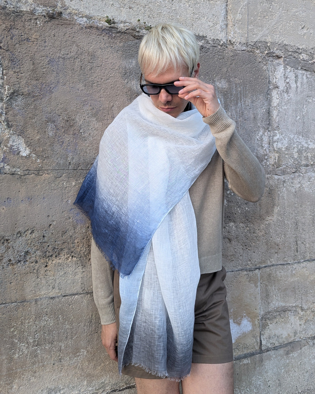 model in beige wears linen scarf in blue, indigo and grey