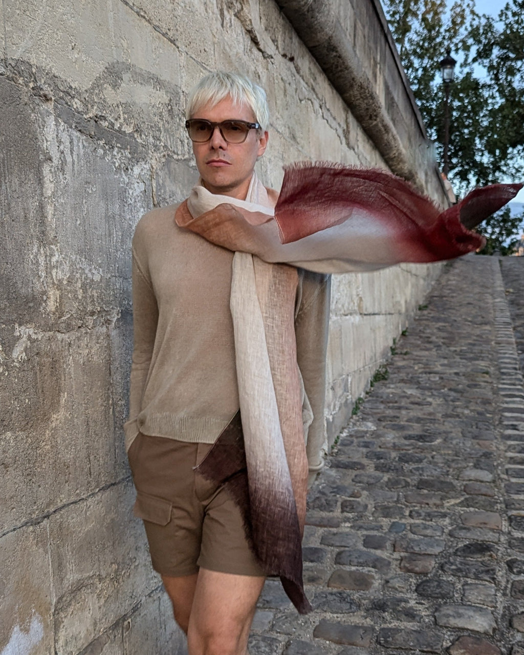 model in beige wears linen scarf in terracotta, brown and green