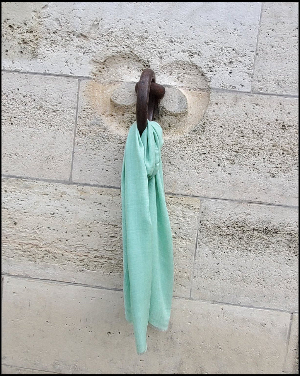light green scarf hangs on the wall