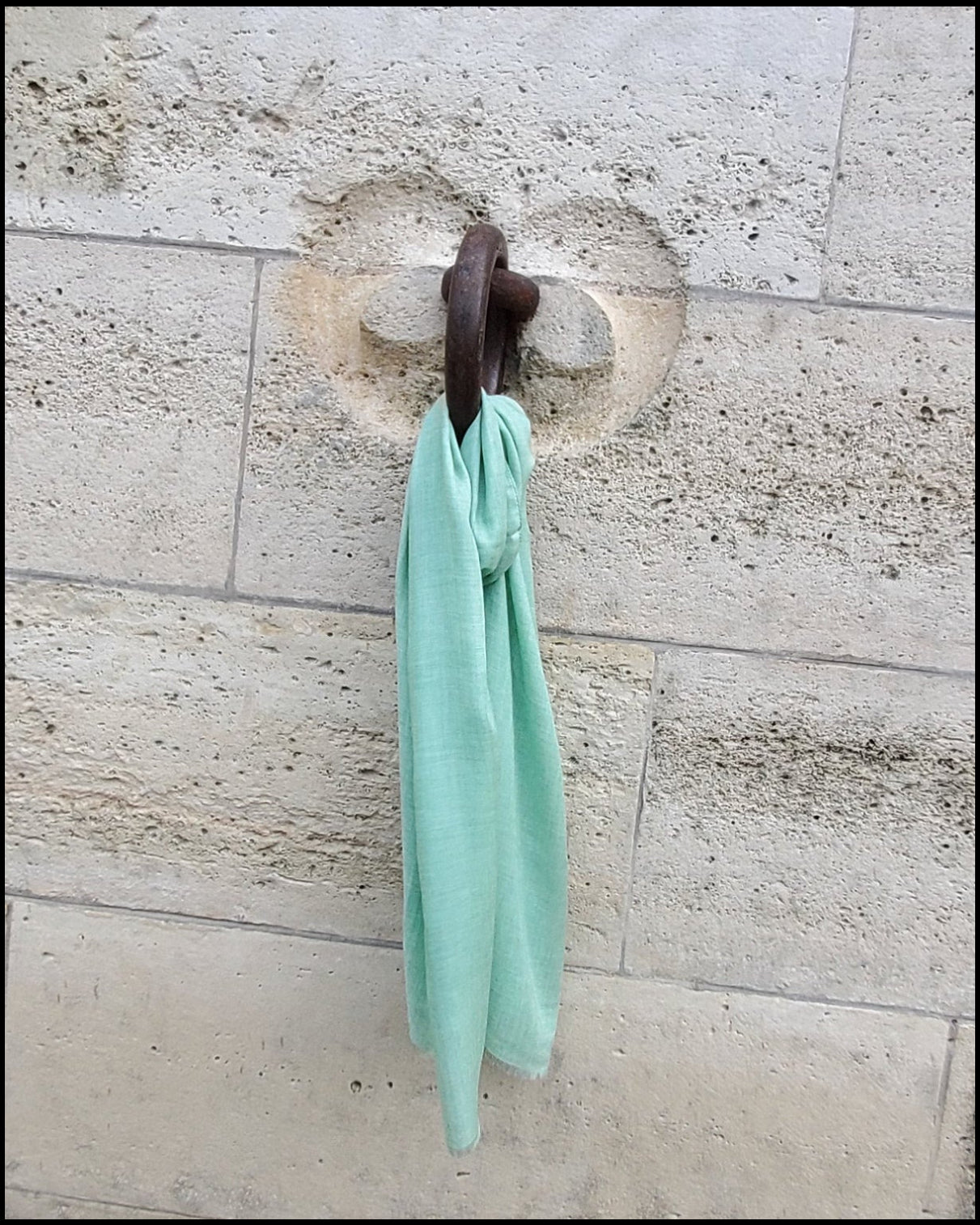 light green scarf hangs on the wall