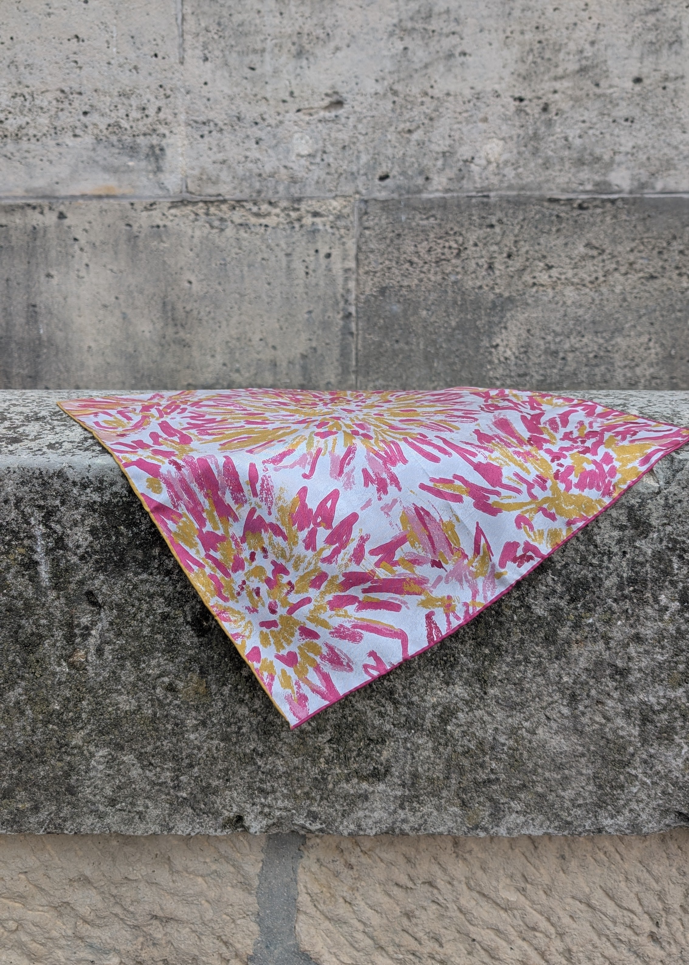 Floral patterned silk foulard on a stone surface